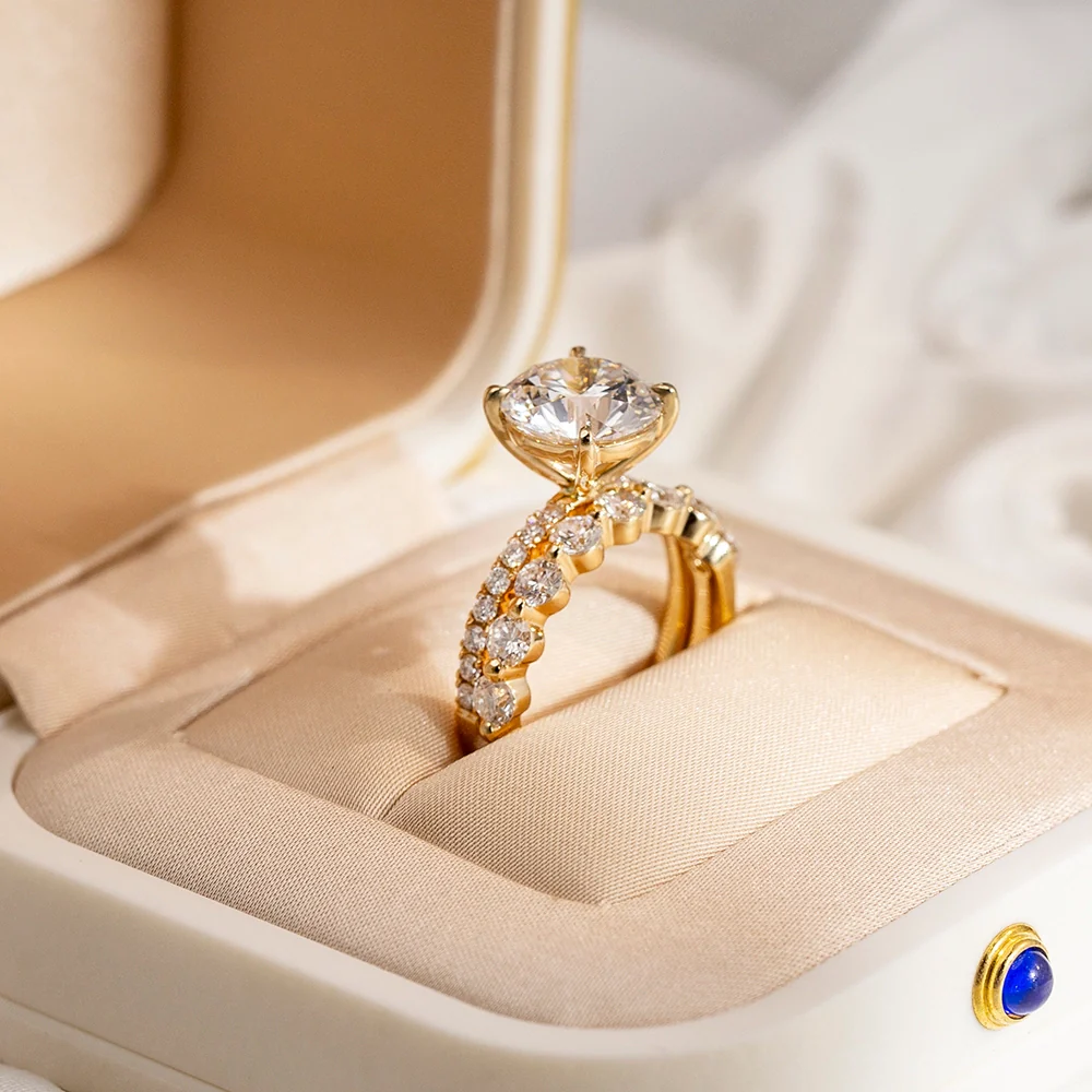 Gold engagement ring with diamonds on a beige ring box
