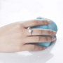 Hand showcasing Rosalind Moissanite Engagement Ring, 1.0ct brilliance 💍✨, with a soft blue background.