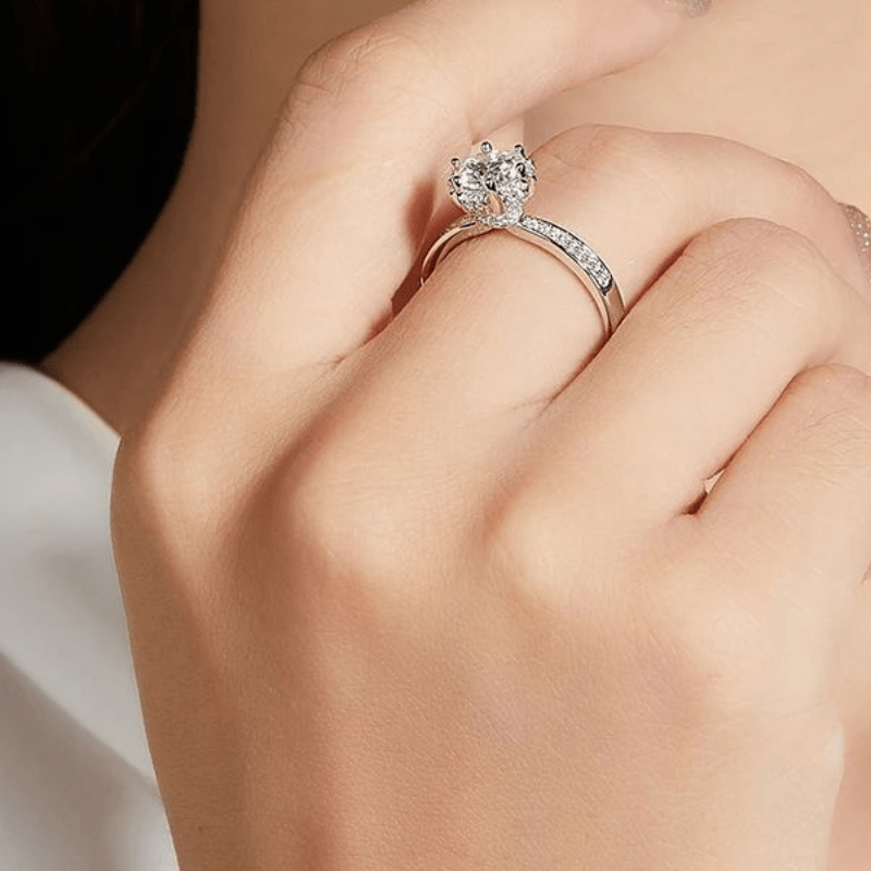 Elegant hand wearing The Alisora Moissanite Crown Ring 💍✨, featuring a sparkling Moissanite centerpiece and pavé-set band. Perfect for engagements!