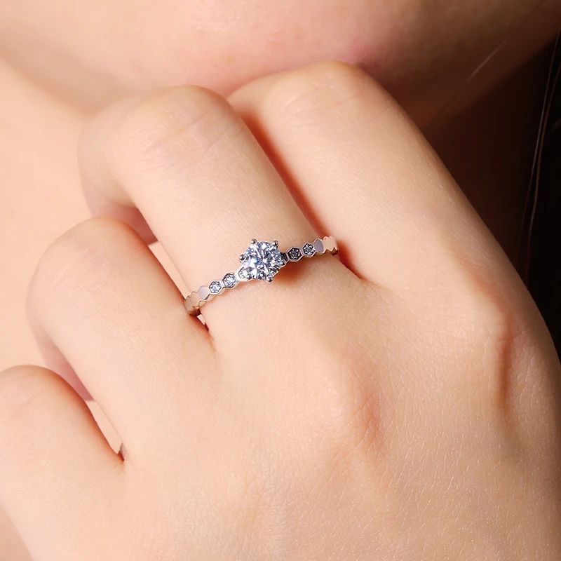 A hand wearing The Astra Moissanite Ring 0.5CT with sparkling accent stones, perfect for engagement or wedding 💍✨.