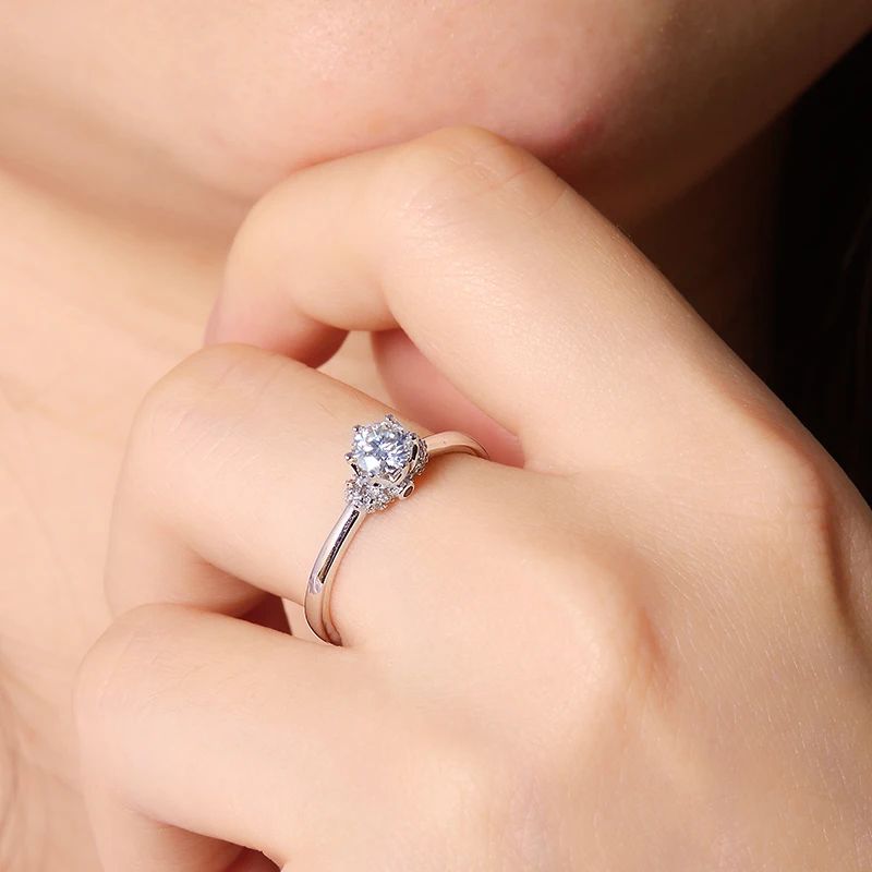 Elegant Moissanite engagement ring showcased on a hand, featuring a stunning round-cut gemstone and a sleek band. 👑✨