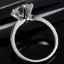 Side view of The Calvienne Round-Cut Moissanite Ring on a black background. Perfect for engagements or weddings! 💍✨