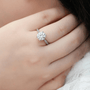 Close-up of a hand wearing a stunning round-cut Moissanite engagement ring with a sleek band. 💍✨ #Moissanite #Wedding