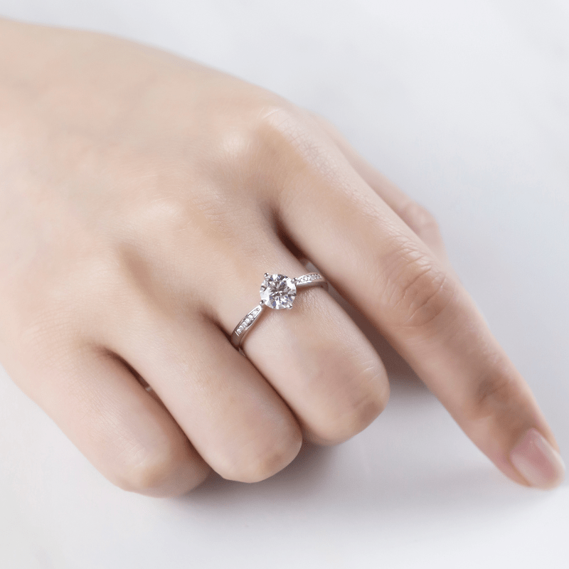 Beautiful hand wearing The Elara Moissanite engagement ring, featuring a sparkling 1CT center stone and elegant side stones. 💍✨