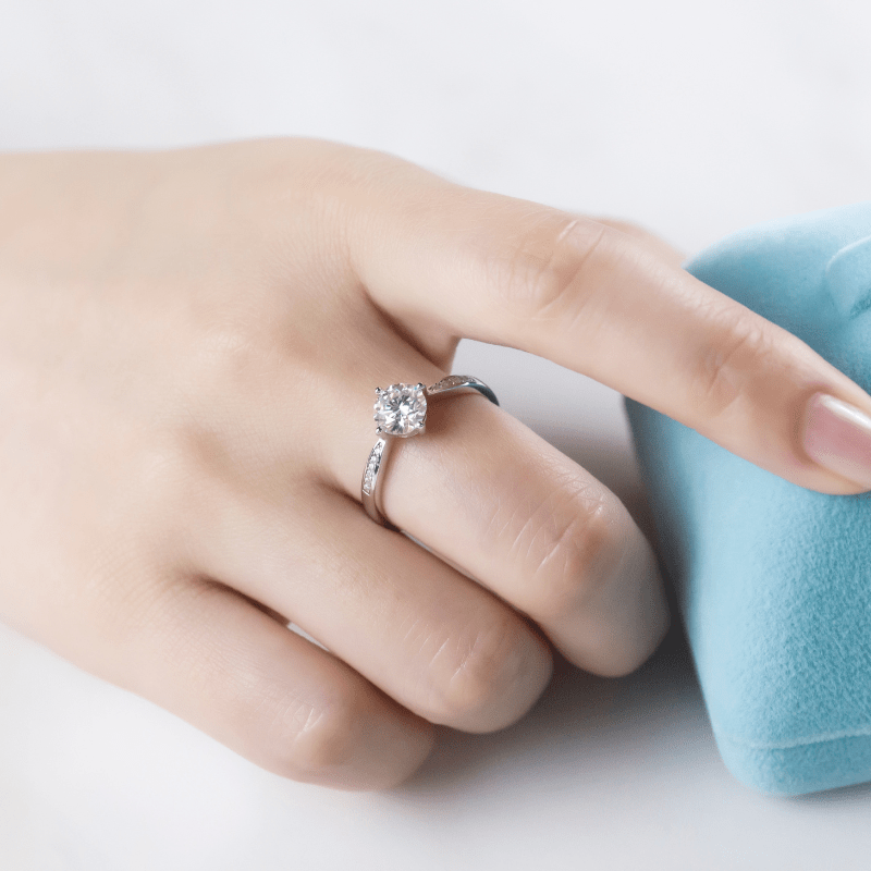 Stunning 1CT Moissanite engagement ring on a hand with side stones, perfect for weddings 💍✨