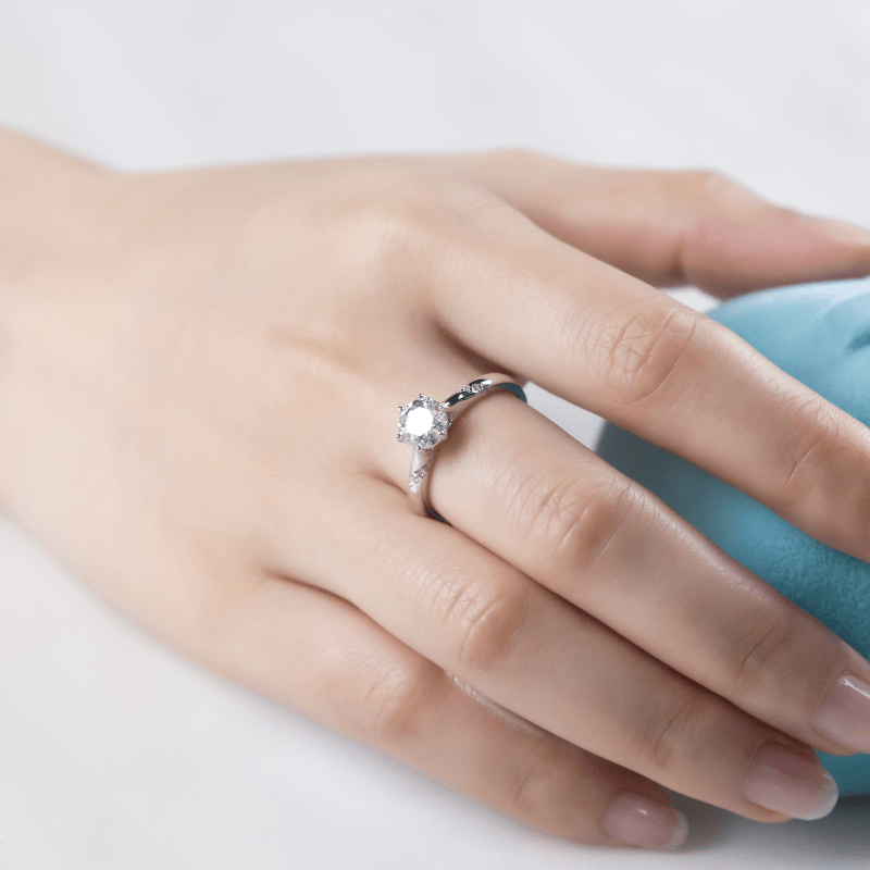 Hand wearing The Evanna Moissanite solitaire ring 💍✨, an elegant engagement piece with stunning brilliance and amazing value!