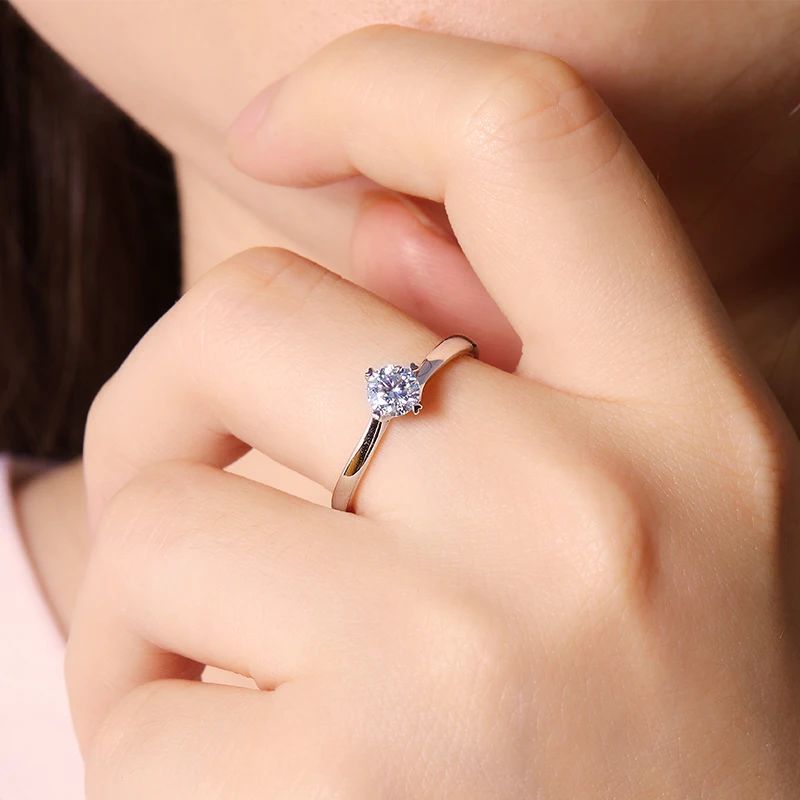 Close-up of a hand wearing The Livia Moissanite solitaire engagement ring 💍, showcasing its stunning sparkle and minimalist design.