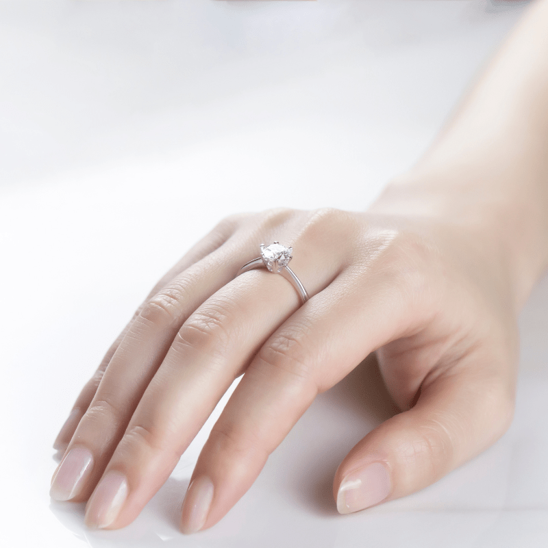 Hand wearing The Selene moissanite solitaire engagement ring 💍✨ - a symbol of elegance and love.