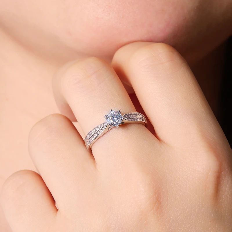 Elegant Seraphielle Moissanite ring featuring a round-cut stone and zirconia side stones. Perfect for engagement 💍✨